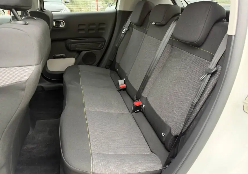 Vue intérieure côté droit de la banquette arrière en tissu gris avec surpiqûres jaunes d'une Citroën C3 Blanc Banquise 2024.