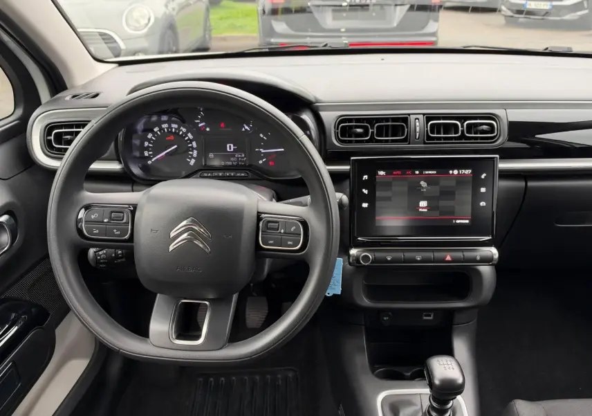 Vue intérieure avant du tableau de bord de la Citroën C3 blanche, avec volant multifonction et écran tactile central.