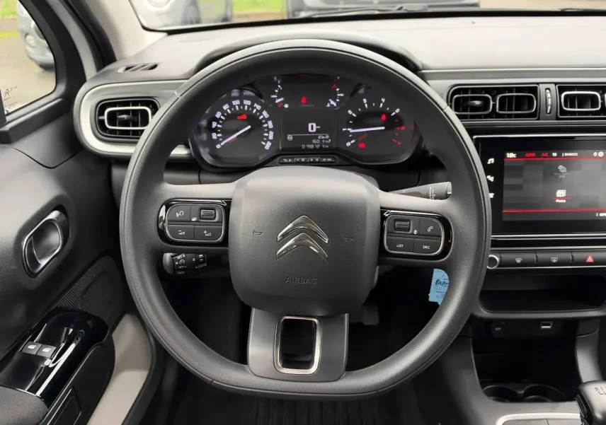 Vue intérieure centrée sur le volant noir de la Citroën C3 2024 avec tableau de bord et écran tactile.