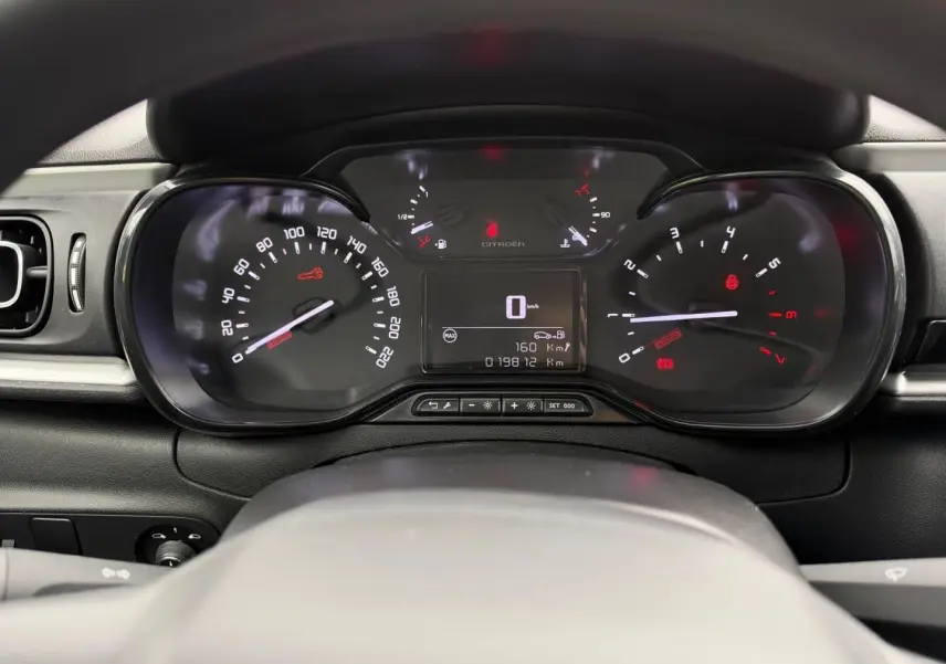 Vue rapprochée du tableau de bord noir de la Citroën C3 2024 avec compteur digital et compte-tours analogique.