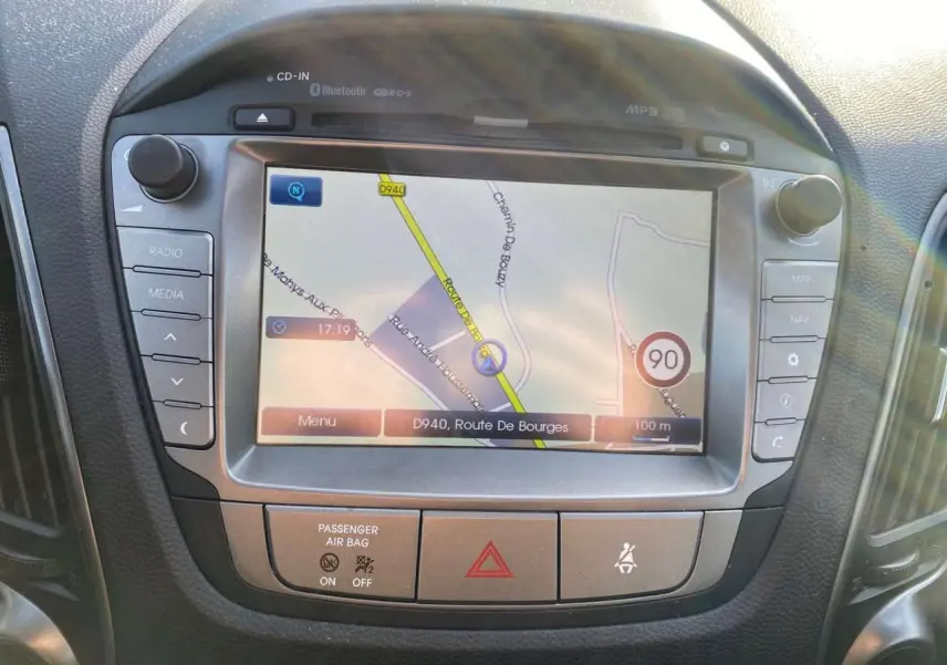 Écran tactile de navigation affichant une carte, intégré au tableau de bord d'un Hyundai ix35 blanc de 2014.