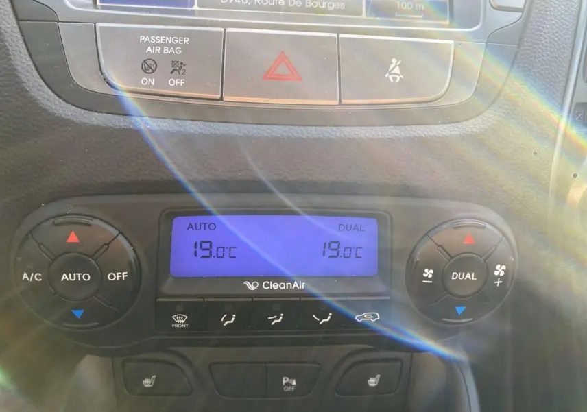 Gros plan sur la console centrale du Hyundai ix35 blanc 2014, affichant la climatisation automatique bi-zone à 19°C.