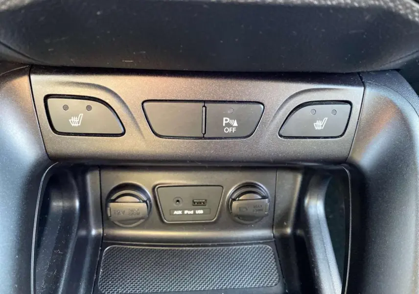 Détail de la console centrale du Hyundai ix35 blanc 2014 montrant les commandes des sièges chauffants et prises 12V, USB, AUX.