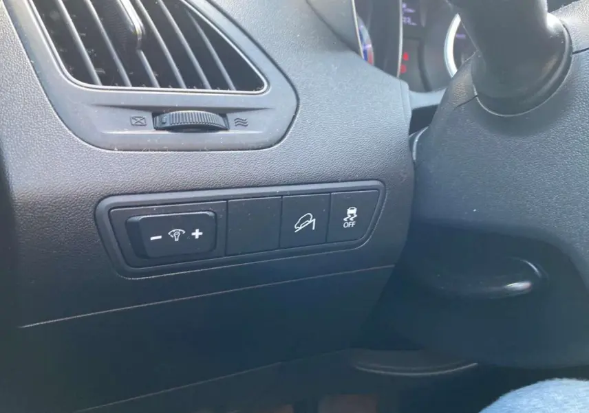 Détail des commandes côté gauche du tableau de bord noir du Hyundai ix35 blanc de 2014.