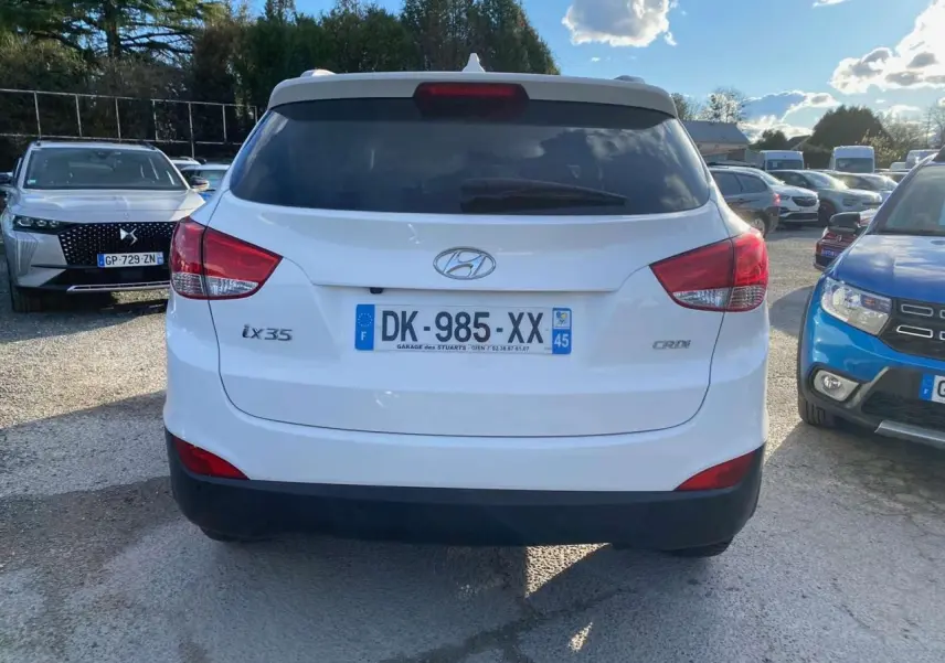 Vue arrière d'un Hyundai ix35 blanc diesel de 2014, avec logo et plaques visibles sur un parking ensoleillé.