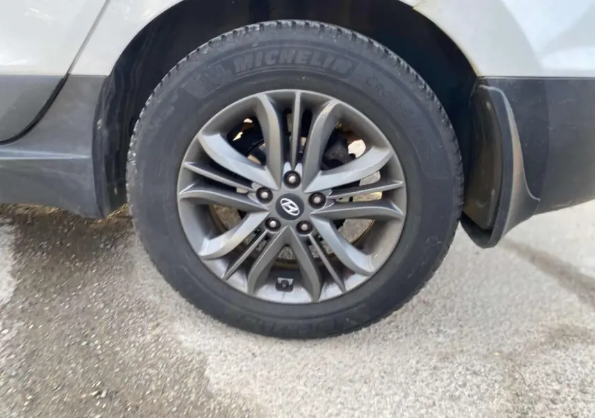 Gros plan sur la roue avant droite du Hyundai ix35 blanc, mettant en valeur la jante alliage et le pneu Michelin.