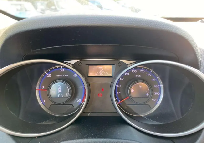 Vue rapprochée du tableau de bord du Hyundai ix35 2014, affichant compte-tours et vitesse avec éclairage bleu.