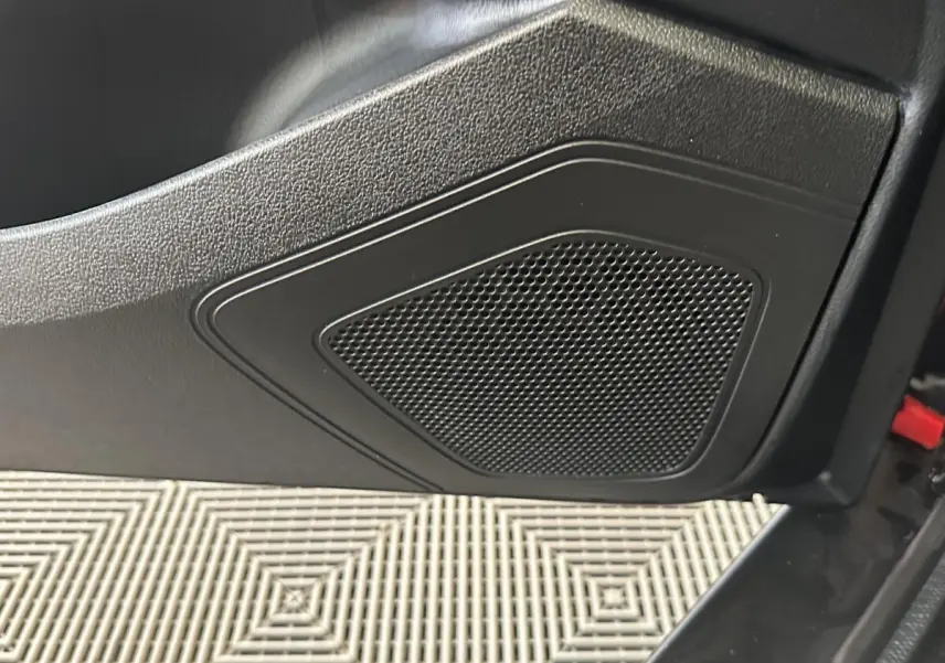 Gros plan sur le haut-parleur intégré à la porte côté conducteur de l'AIXAM AMBITION 0.5 CITY SPORT rouge 2026.