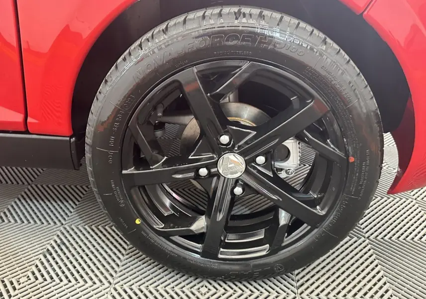 Gros plan sur la roue arrière droite noire brillante de l'AIXAM AMBITION 0.5 CITY SPORT rouge 2026.