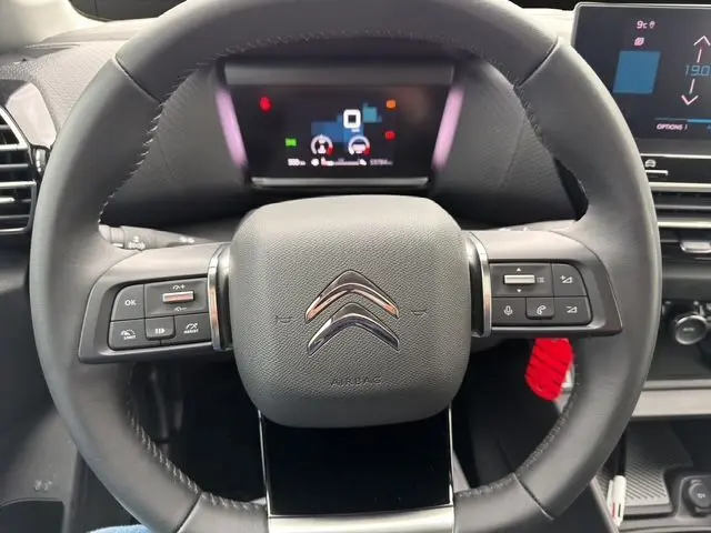 Vue rapprochée du volant noir de la Citroën C4 1.5 BlueHDi 110 Feel Pack avec commandes intégrées et tableau de bord numérique.