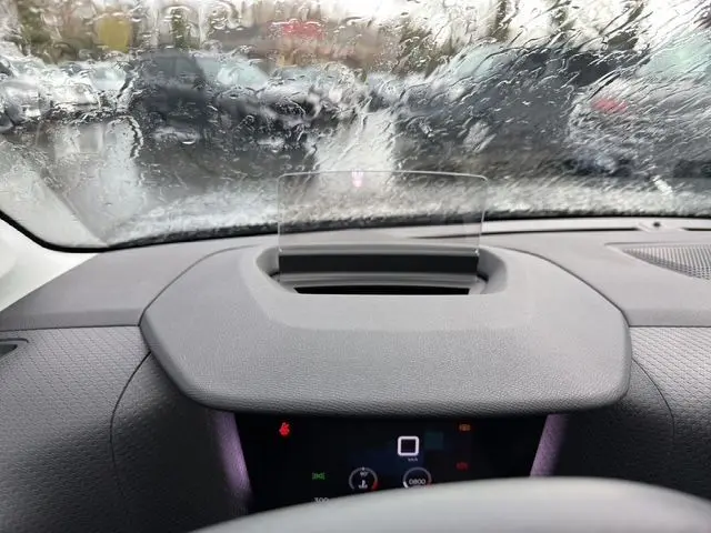Vue intérieure du tableau de bord de la Citroën C4 gris platinium 2022, avec affichage tête haute sous pluie.