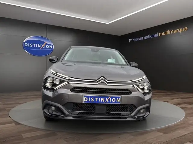 Vue de face d'une Citroën C4 gris platinium 2022, mettant en valeur ses phares LED et sa calandre distinctive.