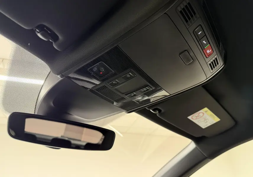 Vue intérieure en plongée du toit noir avec console de plafonnier et rétroviseur d’un Volkswagen Taigo 2025 argent métallisé.