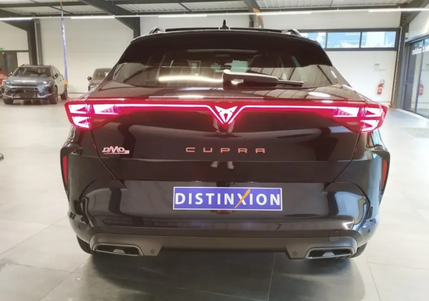 Vue arrière d'une CUPRA Formentor noire métallisée avec signature lumineuse Tri-LED et double sortie d'échappement.