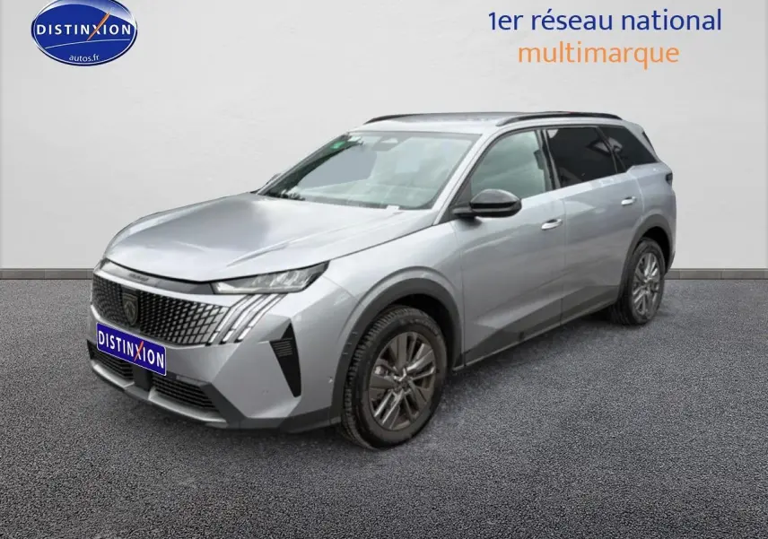 Peugeot 5008 gris artense en 3/4 avant droit, avec calandre distinctive et jantes alu visibles.