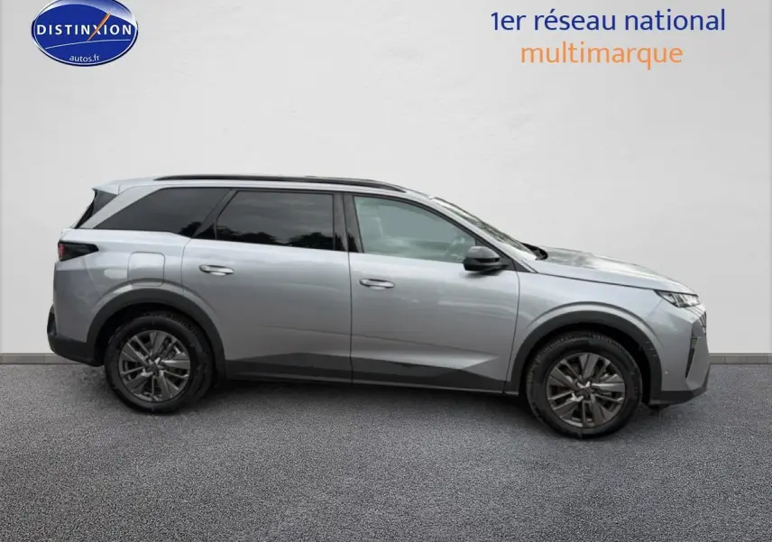Vue de profil côté gauche d’un Peugeot 5008 gris artense avec jantes alu et vitres arrière surteintées.
