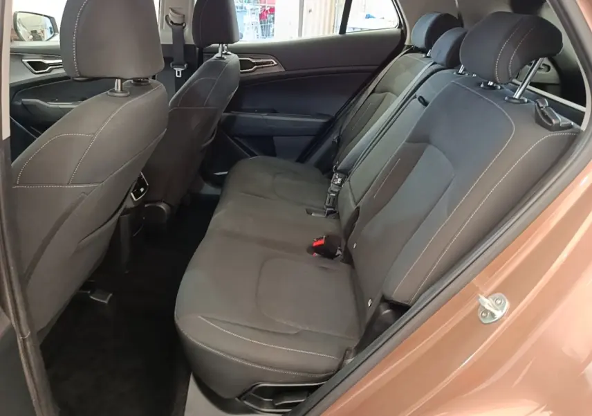 Vue intérieure côté droit sur la banquette arrière noire du Kia Sportage beige 2022, avec appuie-têtes et ceintures visibles.