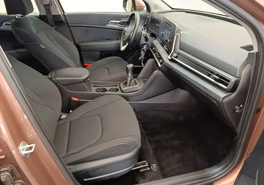 Vue intérieure côté passager avant du Kia Sportage beige 2022, montrant sièges noirs et tableau de bord moderne.