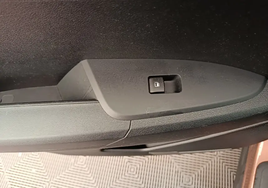 Détail de la commande de verrouillage de porte sur la portière côté conducteur d’un KIA Sportage beige 2022.