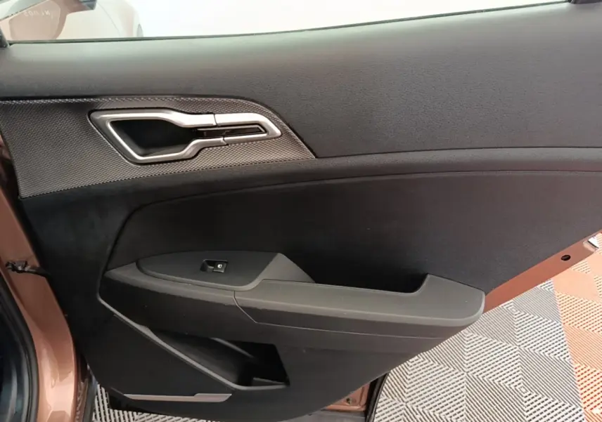 Vue rapprochée de la porte côté conducteur beige du KIA SPORTAGE 2022, avec poignée argentée et commande de vitre.