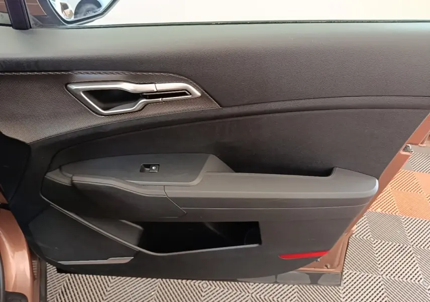 Vue intérieure de la porte avant gauche beige du KIA SPORTAGE 2022 avec poignée argentée et commande de vitre.