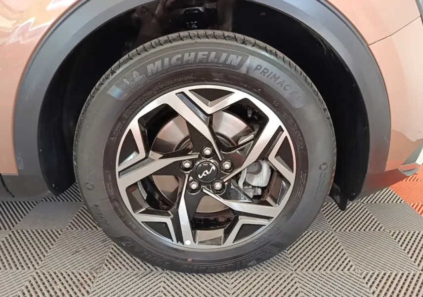 Gros plan sur la roue arrière droite du KIA Sportage beige 2022 avec jante alliage et pneu Michelin visible.