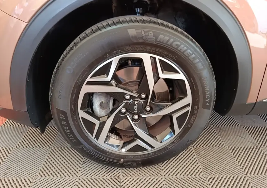 Gros plan sur la roue avant droite beige d’un KIA SPORTAGE 2022 avec jante alliage et pneu Michelin.