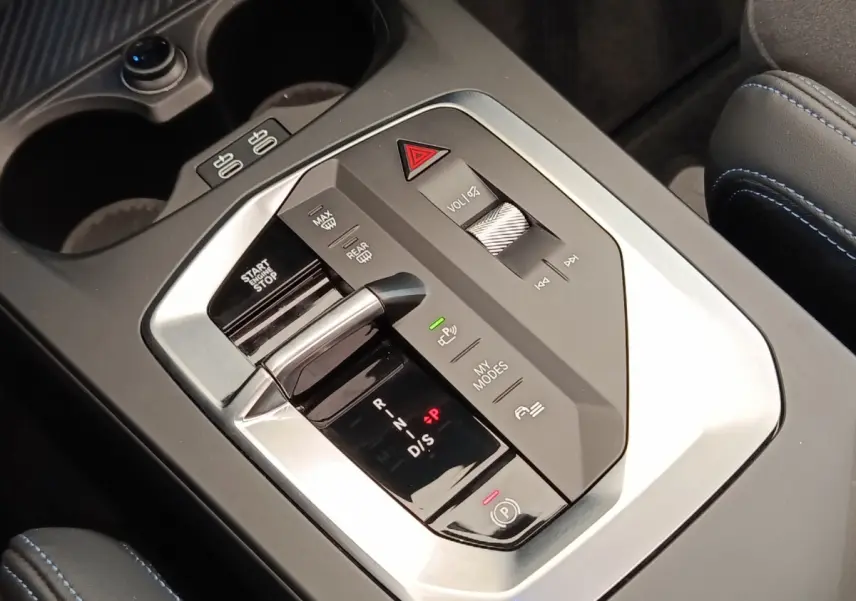 Gros plan sur la console centrale grise de la BMW Série 1 120 DKG7 M Sport avec levier de vitesses et commandes tactiles.