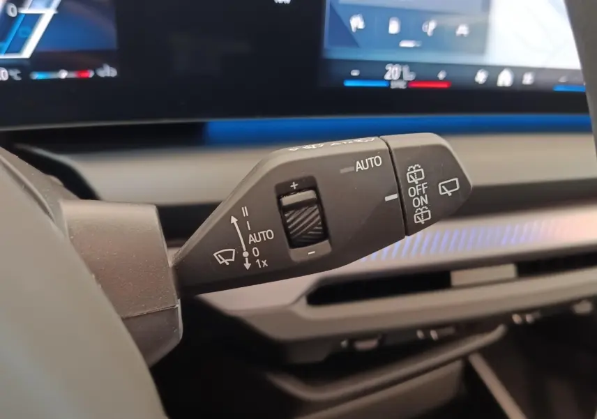 Gros plan sur la commande d’essuie-glace à gauche du volant dans l’habitacle gris clair de la BMW Série 1 120 DKG7 M Sport 2025.