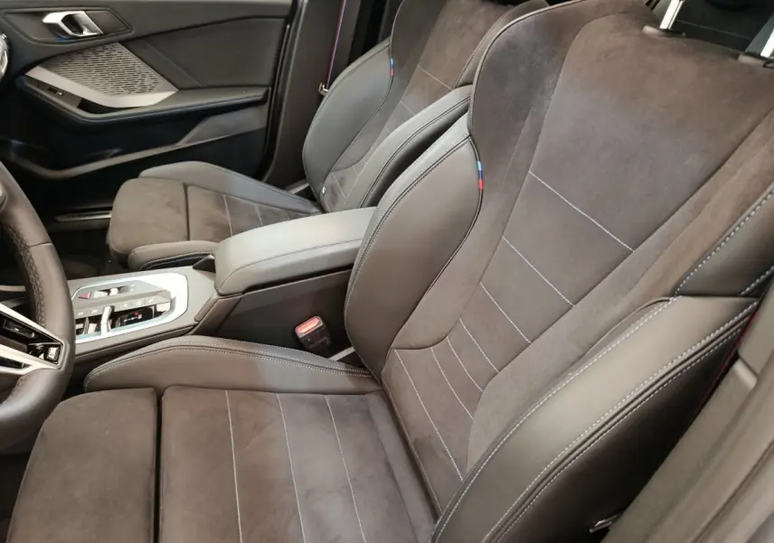 Vue intérieure côté droit des sièges avant en cuir et alcantara gris foncé de la BMW Série 1 120 DKG7 M Sport 2025.
