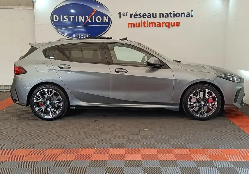 BMW Série 1 120 DKG7 M Sport gris clair vue de profil côté gauche avec jantes alliage et étriers rouges.