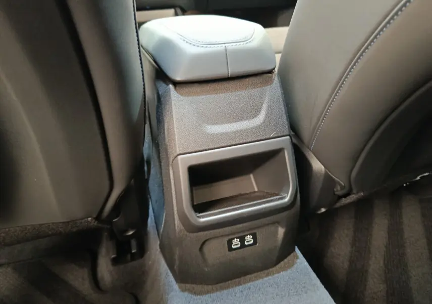 Détail de la console arrière noire avec ports USB dans l’habitacle de la BMW Série 1 120 DKG7 M Sport gris clair.