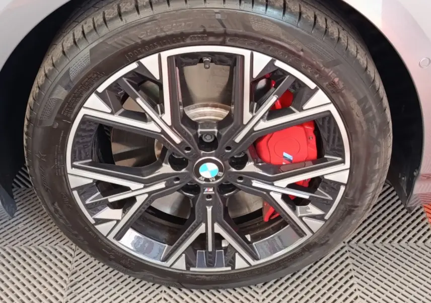 Gros plan sur la roue avant droite de la BMW Série 1 120 DKG7 M Sport gris clair avec étrier de frein rouge M.