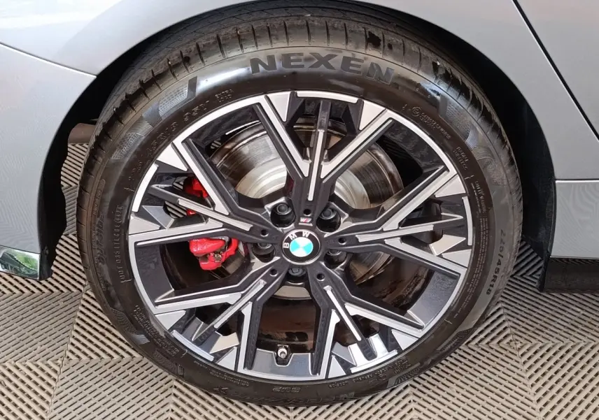 Gros plan sur la roue avant gauche gris clair d'une BMW Série 1 120 DKG7 M Sport avec étrier de frein rouge.