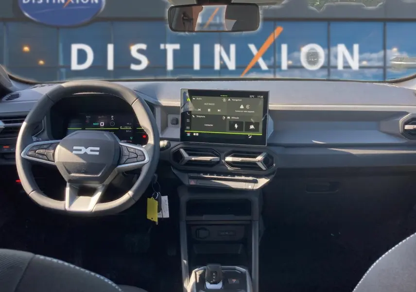 Vue intérieure avant du Dacia Duster 2026 avec tableau de bord moderne et écran tactile central.