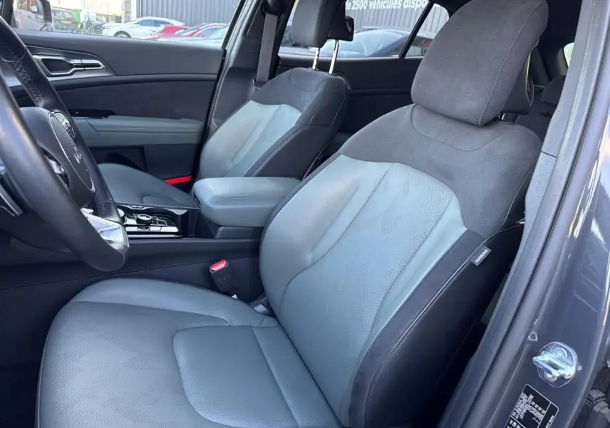 Vue intérieure côté conducteur du Kia Sportage 2025 gris Eclipse, sièges bi-matière synthétique et suédine vert pin.
