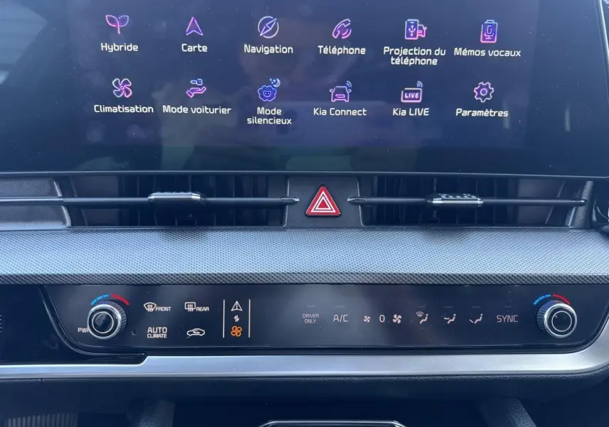 Vue rapprochée de la console centrale du Kia Sportage 2025, écran tactile affichant les options connectées et climatisation automatique.