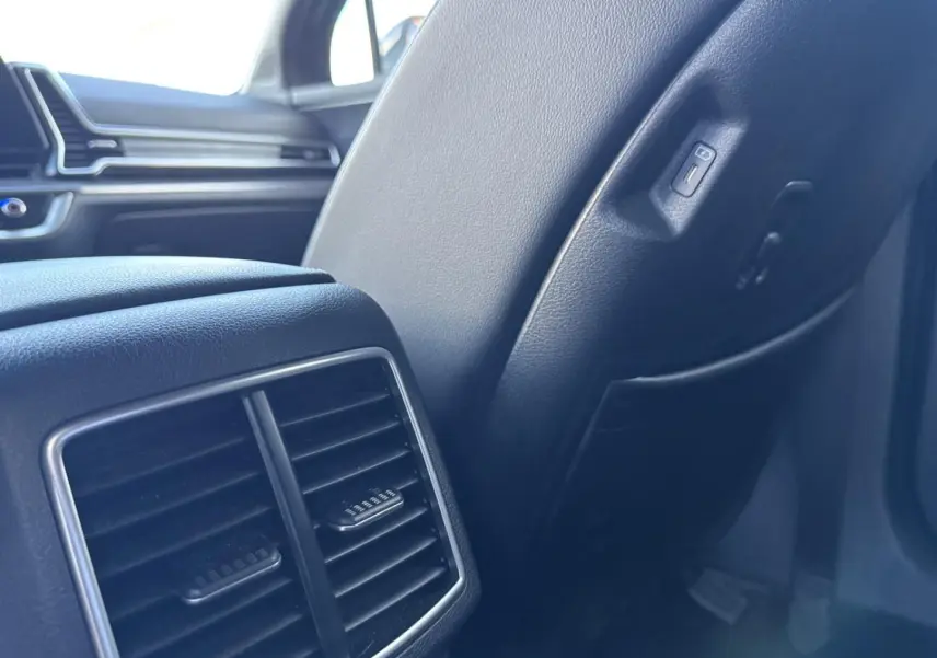 Détail de la console arrière et siège en cuir noir à l'intérieur du Kia Sportage 2025, version hybride.