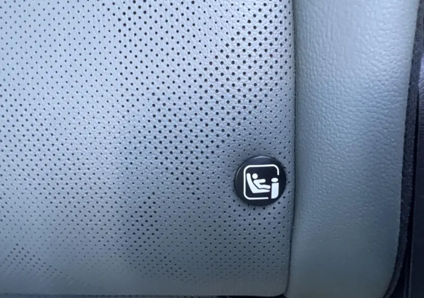 Gros plan sur le logo ISOFIX sur la sellerie grise perforée du siège arrière du KIA SPORTAGE 2025.
