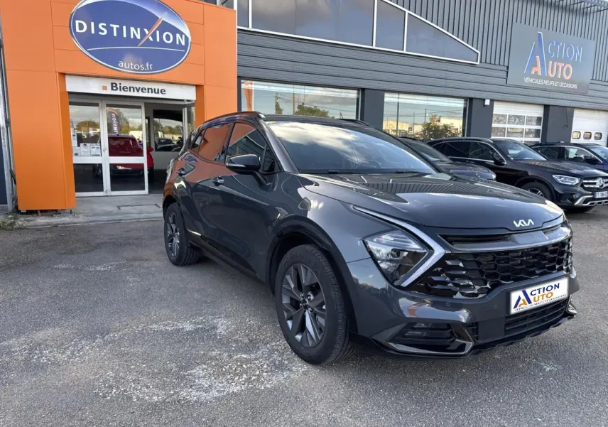 KIA Sportage gris Eclipse métallisé en 3/4 avant droit, avec calandre noire et phares LED distinctifs.