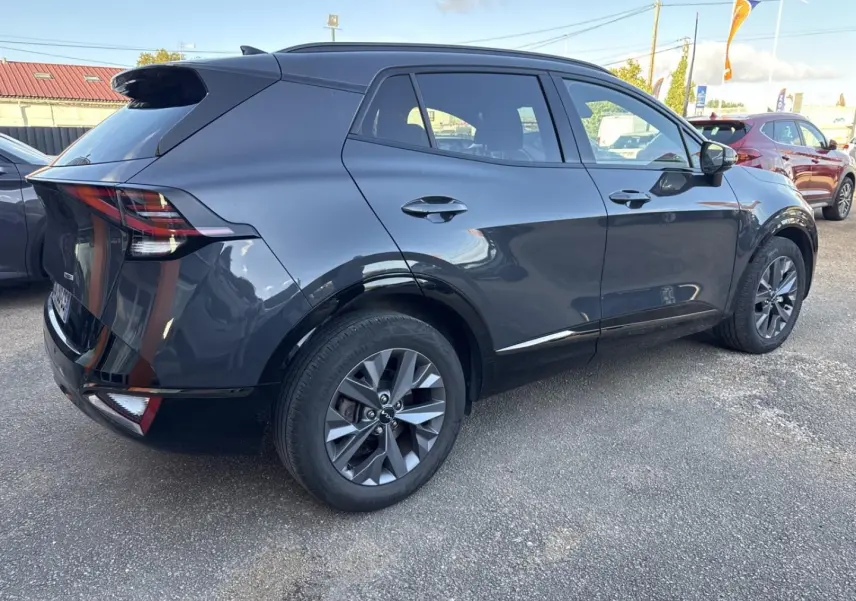 KIA Sportage gris Eclipse métallisé vu en 3/4 arrière droit, avec jantes alliage et feux arrière LED distinctifs.