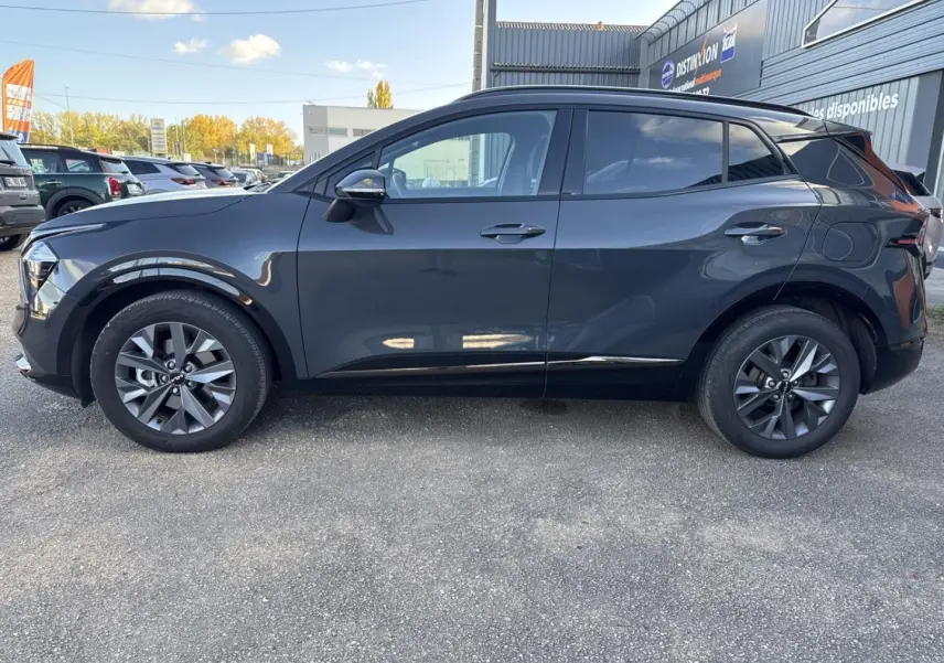 Profil droit d'un KIA SPORTAGE gris Eclipse métallisé 2025, avec jantes alu et vitres surteintées.