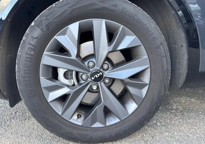 Gros plan sur la jante alu grise et le pneu Continental d’un KIA SPORTAGE 2025 gris Eclipse Métallisée, côté droit.