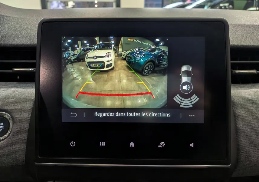 Écran central de la Renault Clio V gris Rafale montrant la caméra de recul avec vue arrière et aides au stationnement.