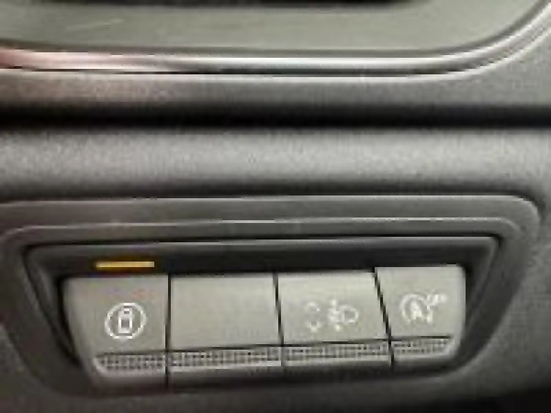 Gros plan sur les boutons de commande du tableau de bord intérieur du Renault Captur rouge 2025.