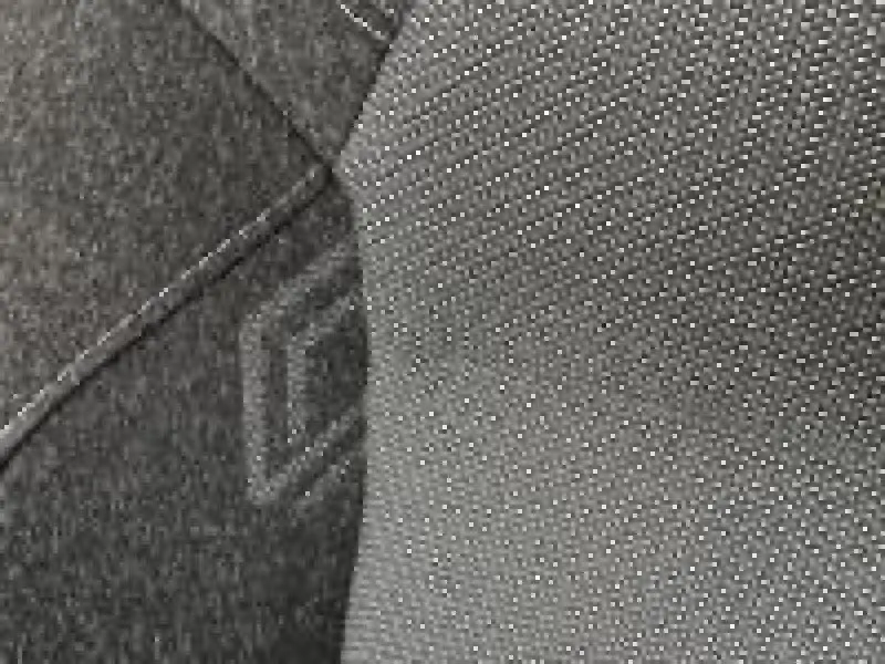 Gros plan sur le tissu gris texturé du siège avant du Renault Captur 1.0 Eco-G 100ch Techno rouge.