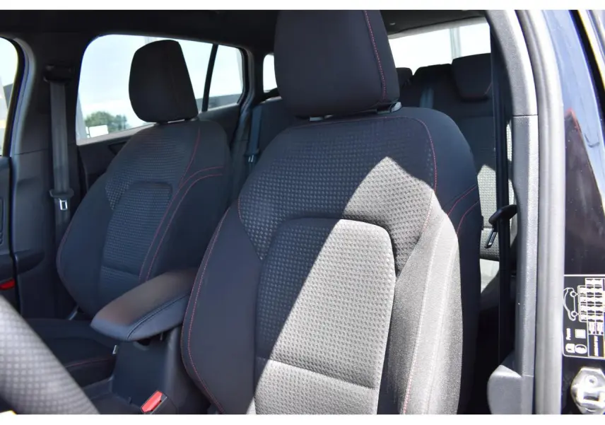 Gros plan sur les sièges avant noirs avec surpiqûres rouges de la Ford Focus SW 1.5 EcoBlue 115 Powershift ST LINE X.