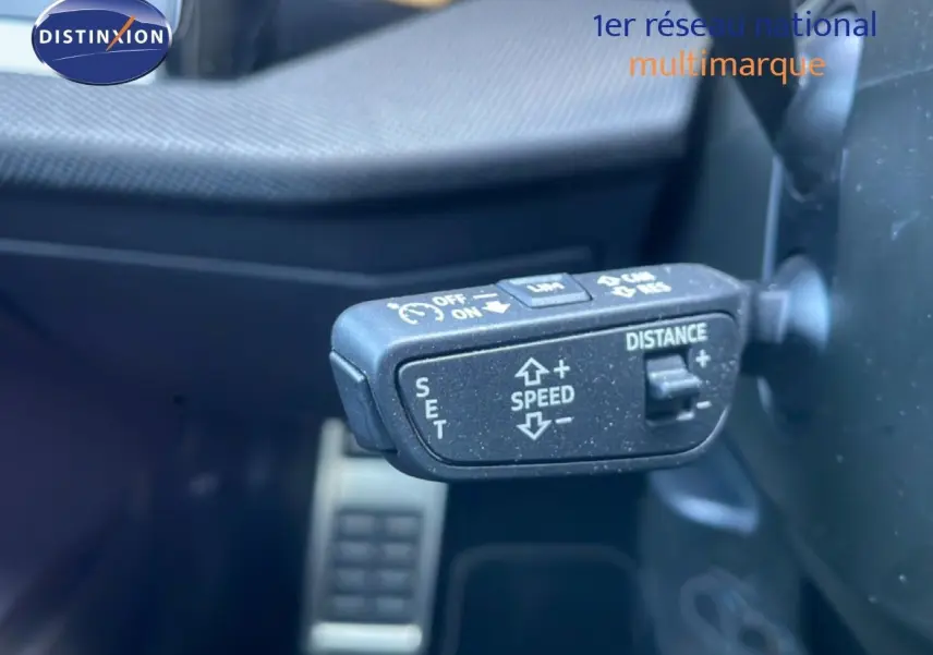 Gros plan sur la commande de régulateur de vitesse adaptatif dans l’Audi A3 Sportback noir mito metal, intérieur côté gauche.