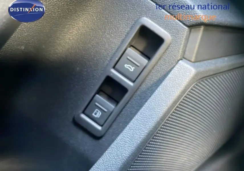 Gros plan sur les boutons d’ouverture du coffre et de la trappe à carburant dans l’habitacle noir de l’Audi A3 Sportback 2025.
