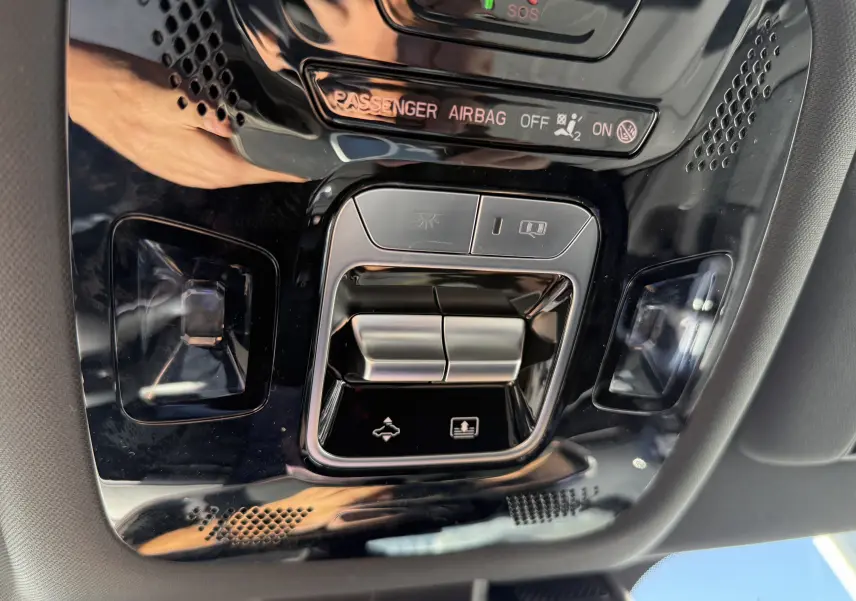 Vue rapprochée du panneau de commandes intérieures noires du JAECOO J7 PHEV 2026, avec boutons de lumière et airbag passager.